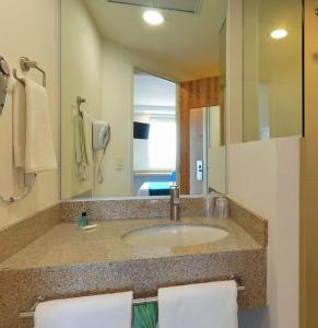 La salle de bains est pourvue d'un lavabo et d'un grand miroir. dans l'établissement One Silao, à Silao