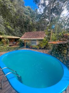 une grande piscine bleue en face d'une maison dans l'établissement Pousada Lua Bonita, à Nova Lima