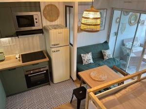 a small kitchen with a couch and a table in a caravan at Tropical Duplex : Bord de mer + Piscine in Frontignan +69 photos