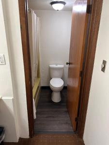 a bathroom with a toilet and a door open at Budget Inn Motel in Storm Lake +12 photos