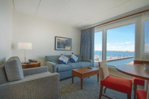 a living room with a couch and a table and a large window at Club Wyndham Inn on the Harbor in Newport