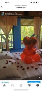 a picture of a bed with red hearts on it at Pousada Lua Bonita in Nova Lima