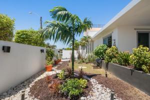 a house with a palm tree in the yard at Pool House by Isla Verde Beach home in San Juan