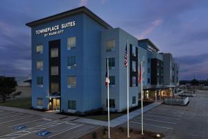 un edificio con dos banderas en un estacionamiento en TownePlace Suites by Marriott Abilene Southwest, en Abilene