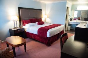 um quarto com uma cama grande e um cobertor vermelho em Cottonwood Inn em Salem