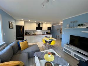 a living room with a couch and a table and a kitchen at Apartament Katarzyna in Międzywodzie