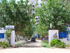 una carretera con árboles y un coche aparcado en ella en Appart Hôtel La Planque, en Oued Laou