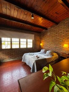 a bedroom with two beds and a brick wall at Casa 'Los Colibries' in Salta