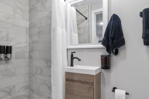 uma casa de banho com um lavatório e um espelho em Midcentury Guest Suite w/ King Size Bed em Baltimore