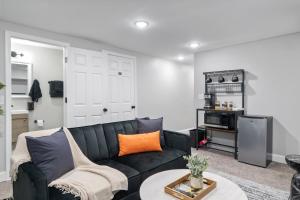 ein Wohnzimmer mit einem schwarzen Sofa und einem Tisch in der Unterkunft Midcentury Guest Suite w/ King Size Bed in Baltimore