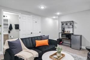 a living room with a black couch and a table at Midcentury Guest Suite w/ King Size Bed in Baltimore