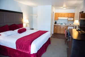 Una habitación de hotel con una cama grande y una cocina. en Cottonwood Inn, en Salem