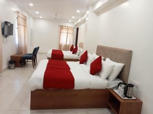 um quarto com 2 camas com lençóis vermelhos e brancos em Hotel Fortune Residency em Nova Deli