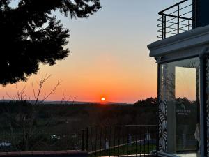 a sunset from a building with the sun in the background at Green Roof Boutique Hotel & Spa in Terkos