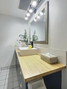een badkamer met een witte wastafel en een spiegel bij The Sunbeam in Mont-Tremblant