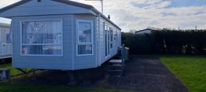 a blue tiny house sitting in a yard at Gold star 6 birth caravan in Berrow