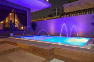 uma piscina numa casa com iluminação roxa em فلل كاسا الفندقية em Riade