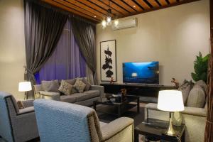 a living room with couches and a flat screen tv at فلل كاسا الفندقية in Riyadh