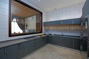 a kitchen with blue cabinets and a sink and a window at فلل كاسا الفندقية in Riyadh