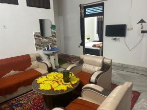 a living room with a couch and a table with flowers at Entire family vacation home in Vrindāvan