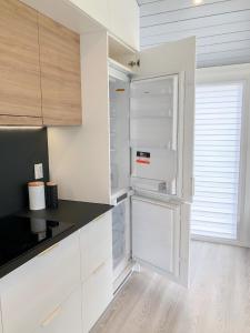 a white refrigerator in a kitchen with white cabinets at Ferienhaus in Rohrbach An Der Gölsen mit Garten, Grill und Terrasse in Rohrbach An Der Gölsen
