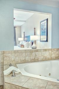 een badkamer met een bad en een spiegel bij Club Wyndham Old Town Alexandria in Alexandria