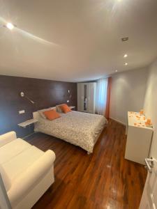 a bedroom with a bed and a white couch at Finca Antonio in Ciudad-Rodrigo