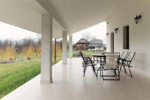 un patio con mesa, sillas y un campo en The Ivory House, en Satu Nou de Sus