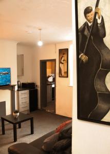 a living room with a painting of a man at AmazenHome - Stylish 3 bed - House of Ebony in Leigh