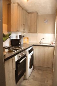 a kitchen with a sink and a stove and a dishwasher at AmazenHome - Stylish 3 bed - House of Ebony in Leigh