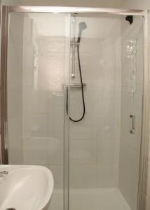 a shower with a glass door next to a sink at AmazenHome - Stylish 3 bed - House of Ebony in Leigh