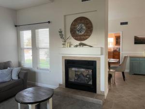 a living room with a fireplace with a clock on the wall at Our Farmhouse, Our Place: Cozy and Cute homestead! in Paso Robles