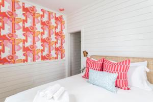 a bedroom with a bed with red and white pillows at Royal Cottage I in Charleston