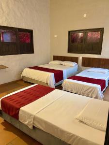 a bedroom with three beds in a room at EcoHotel Inka Minka in Santa Marta