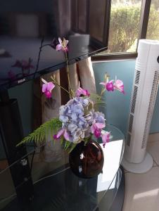a vase with purple flowers on a glass table at Riverside Home La Fortuna in Tanque