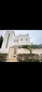 ein großes weißes Gebäude mit einer Tür drauf in der Unterkunft Villa lucky in Hammamet