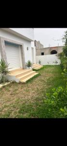 a house with wooden steps leading to a garage at Villa lucky in Hammamet