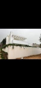 a white building sitting on top of a wall at Villa lucky in Hammamet