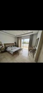 um quarto com uma cama e uma grande janela em Villa lucky em Hammamet