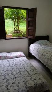 two beds sitting in a room with a window at Chalet De Chalo in Jardin