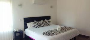 um quarto com uma cama com uma cabeceira e almofadas pretas em HOTEL PUNTA GALERIA em Morelia