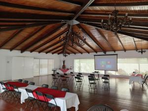 uma grande sala com mesas e cadeiras e uma tela de projeção em HOTEL PUNTA GALERIA em Morelia