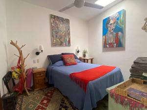 - une chambre avec un lit et un ventilateur de plafond dans l'établissement Casita del Artista, à San Patricio - Melaque