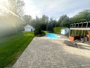 a backyard with a swimming pool and a building at L'Oasis Urbaine in Saint-Hubert