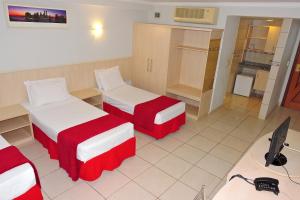a hotel room with two beds and a desk at Bay Park Hotel Resort in Brasília