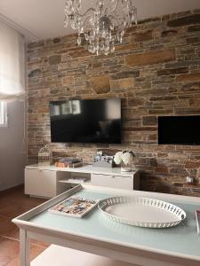 una sala de estar con una pared de piedra y una mesa. en BenedettaMolinaseca VuT en Molinaseca