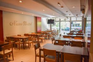 un restaurante con mesas y sillas y un cartel en la pared en Nuevo Hotel Bristol en Santiago del Estero