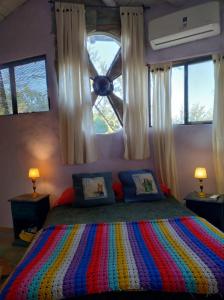 a bedroom with a colorful bed with a window at CasaIsolina in San Javier