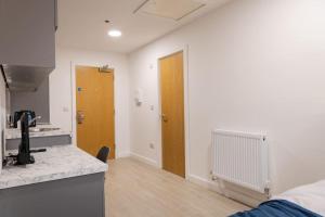 a kitchen with a counter and a door in a room at Central Studio: Old Trafford in Manchester