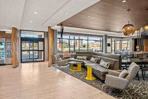 una sala de estar con sofás, mesas y ventanas en SpringHill Suites by Marriott Menomonee Falls, en Menomonee Falls